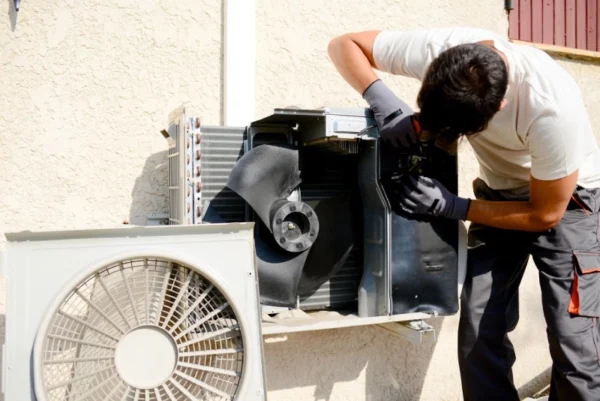 A man working on an air conditioner unit.