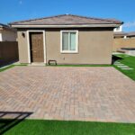 Backyard guest house with brick patio and turf
