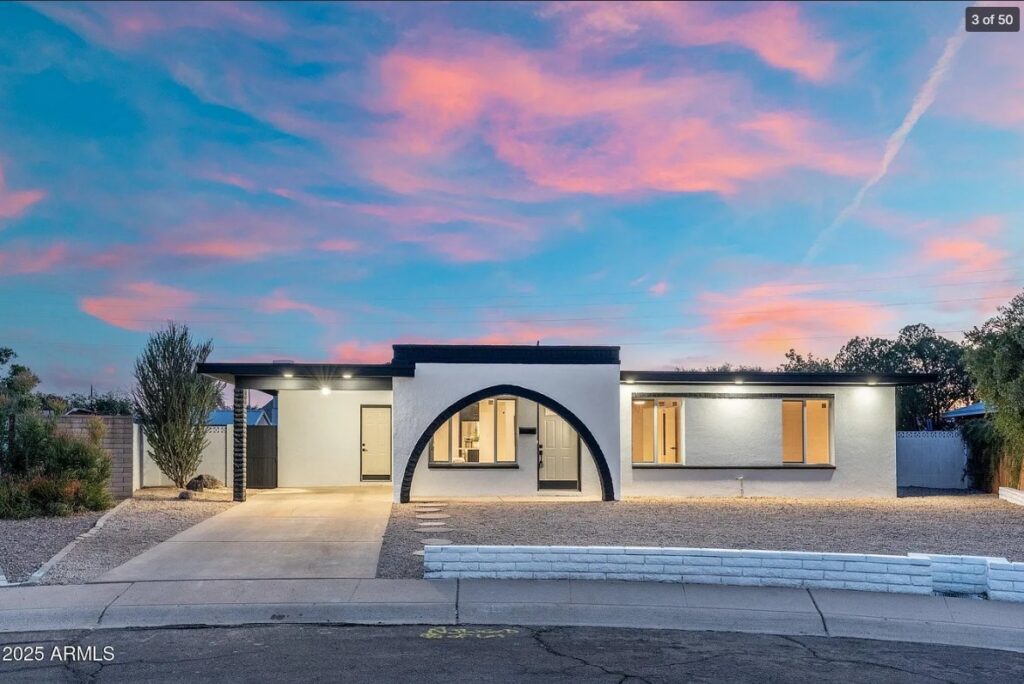 Modern house with arched entry under pink sunset